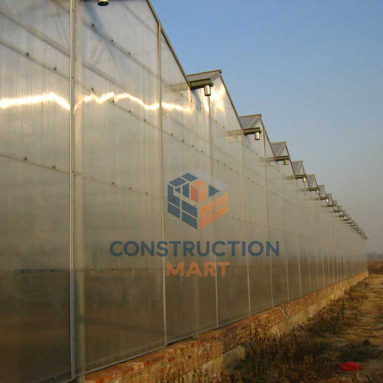 Agricultural greenhouse made of Constructionmart polycarbonate sheets, showing a corner view of connected greenhouse rows designed for large-scale farming use.