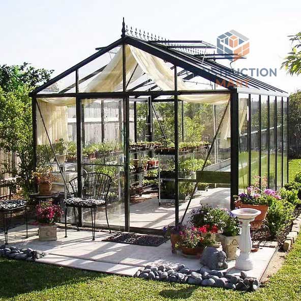 Freestanding polycarbonate greenhouse with a decorative garden interior, designed by Constructionmart for growing flowers and ornamental plants in all seasons.